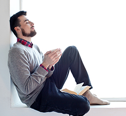 man relaxing by window