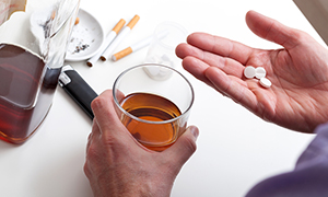 man taking pills with alcohol