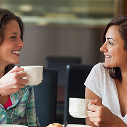 two-women-talking-with-coffee-in-hand-social-support