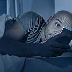 addicted-to-smartphone-internet-man-in-bed-at-night