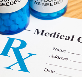 medical-prescription-with-blue-pill-bottle-on-top-of-paper-prescription