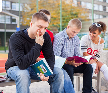 Student with books thinking on bleachers