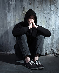 Young Man sitting on ground with head in hands