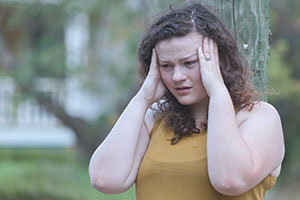 woman holding her temples dealing with anxiety